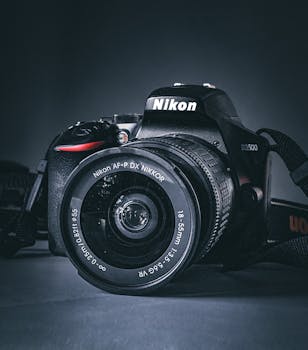 Detailed image of a DSLR camera with a focus on the lens, perfect for photography enthusiasts.
