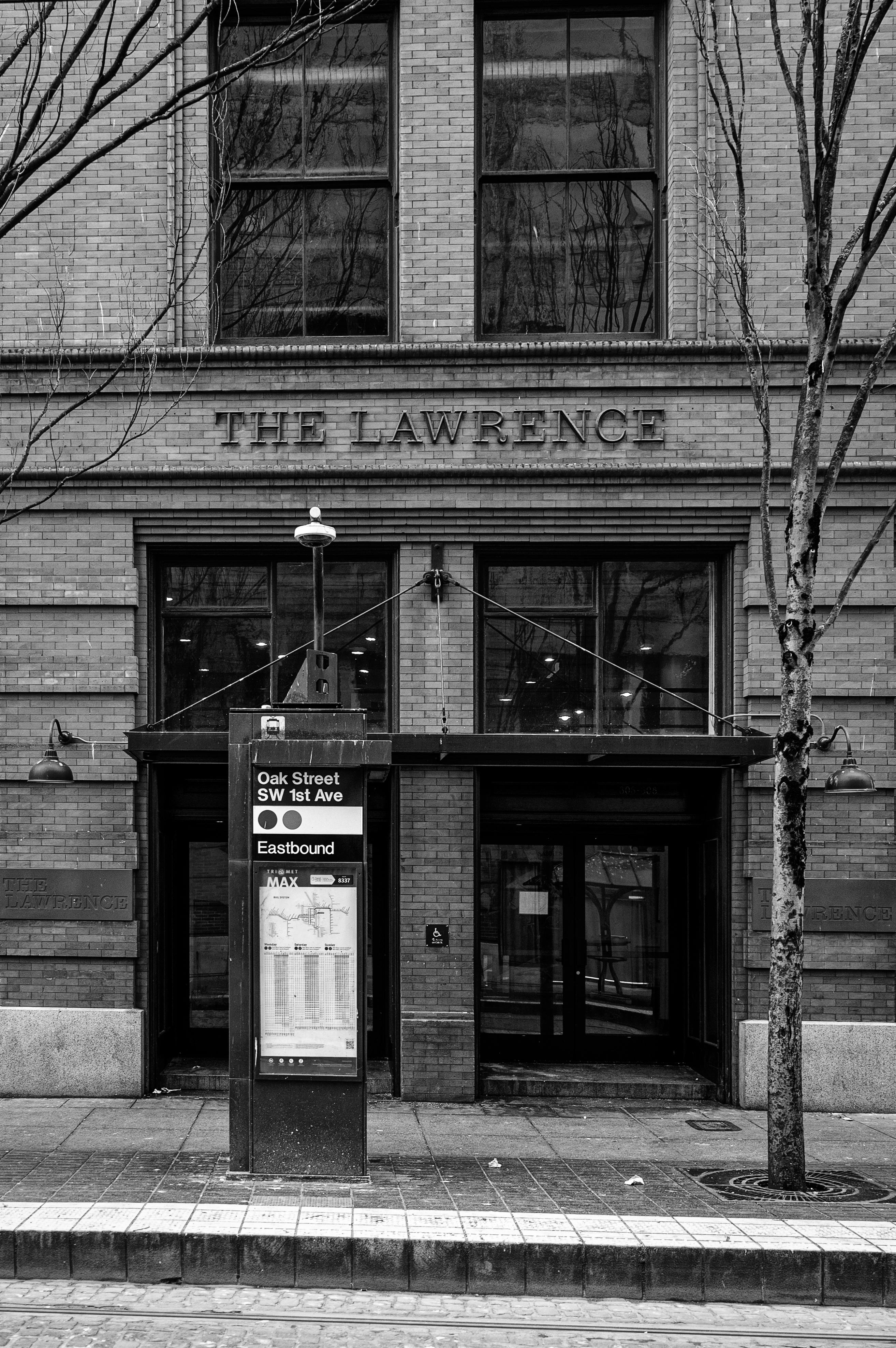 Monochrome image of Oak Street bus stop at The Lawrence building in Portland, Oregon.