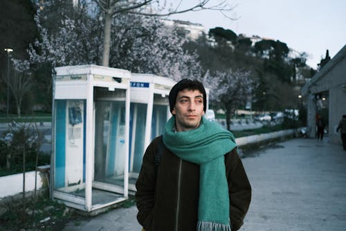 Man with Green Scarf on Street in Winter