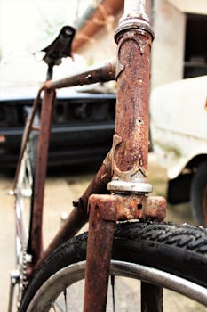 A detailed view of a heavily rusted bicycle frame viewed outdoors in daylight.