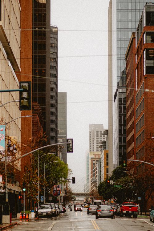Free Dynamic city street view with skyscrapers and bustling traffic under overcast skies. Stock Photo