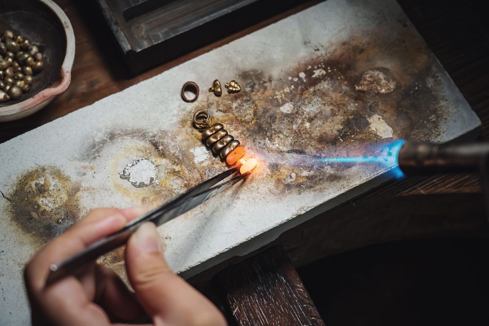 A jeweller soldering at the bench