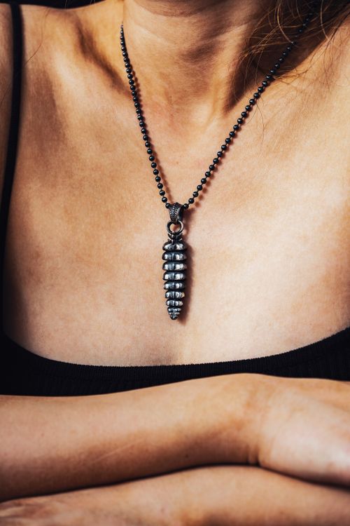 Free Close-up of a silver rattlesnake tail pendant necklace on a woman's neck. Stock Photo