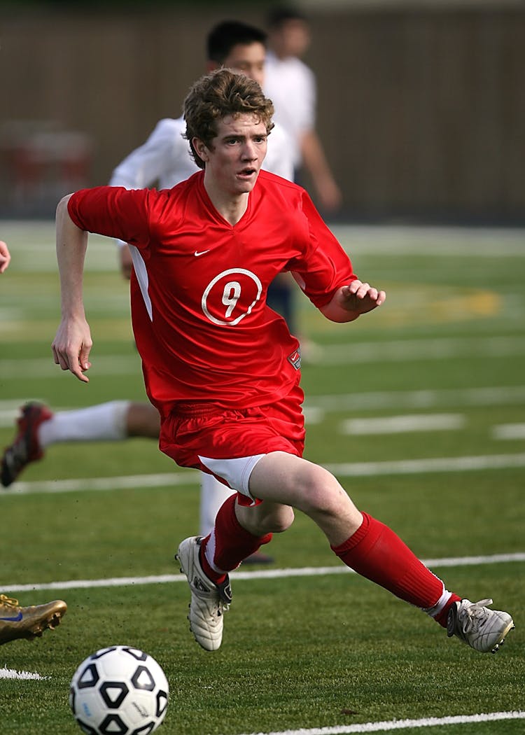 Man In Red Nike Jersey Shirt Playing Soccer