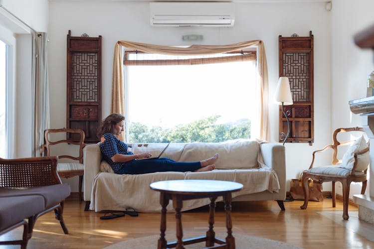 Woman Sitting On Sofa In Living Room