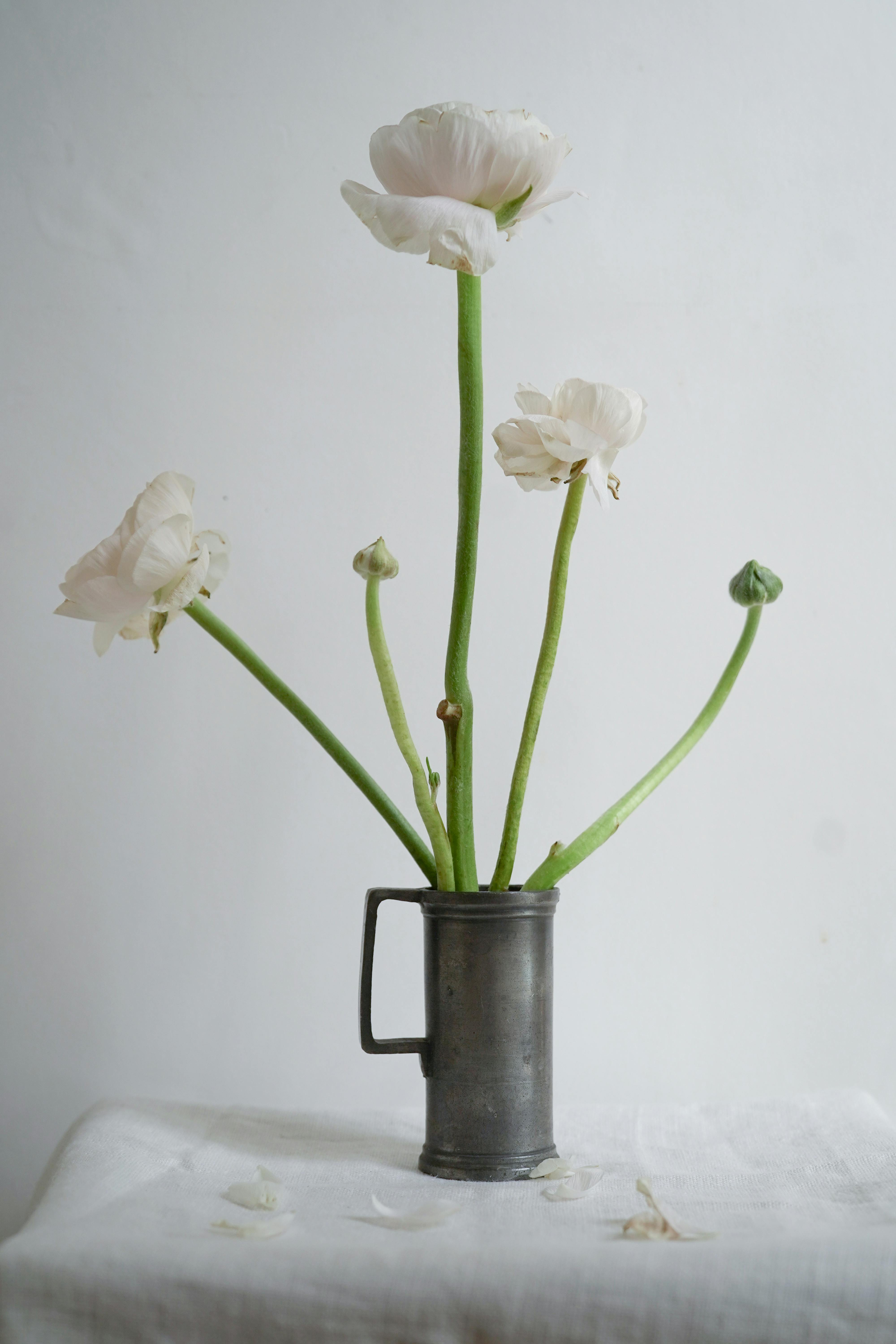 A close-up of white flowers arranged in a metal vase, ideal for decor inspiration.