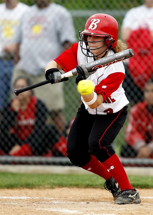 Free Focused female softball player in action swinging bat during outdoor game. Stock Photo