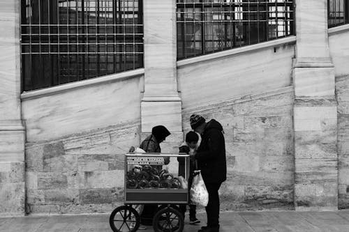 Woman, Child and Man Standing Near Cart on Sidewalk