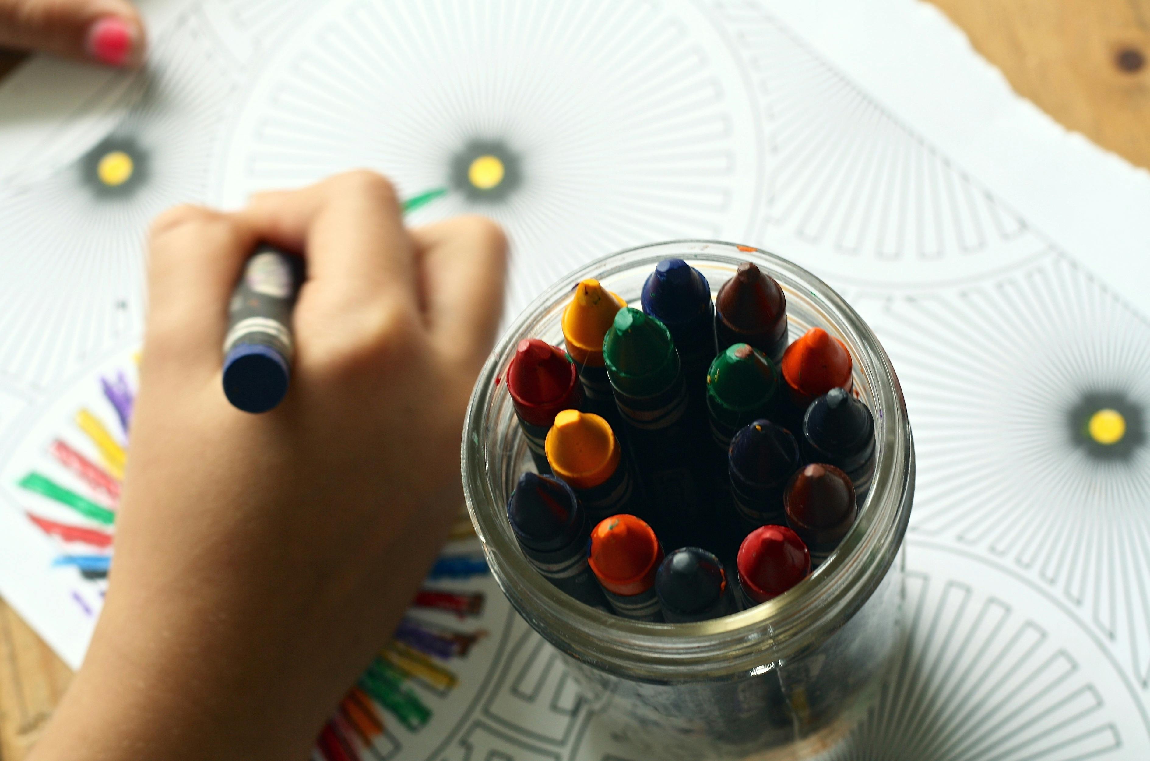 A student coloring art with crayons. | Photo: Pexels