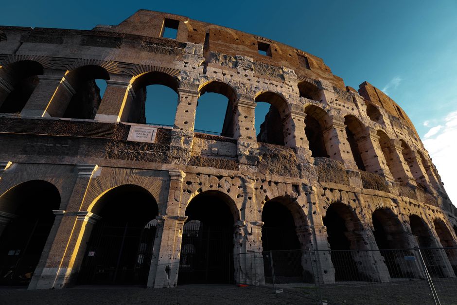 Stunning view of the Colosseum with warm evening light highlighting its historic architecture.