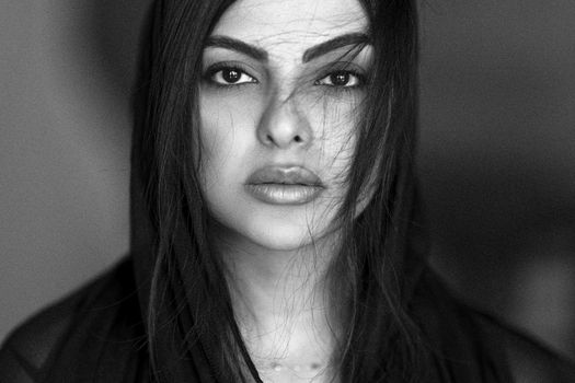 Striking black and white portrait of a young woman with intense gaze.