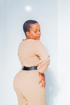 Stylish fashion portrait of a woman in a beige outfit with short hair, photographed indoors.