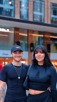 Stylish young couple smiling in urban setting wearing sportswear and accessories. - Fotografer Sidoarjo