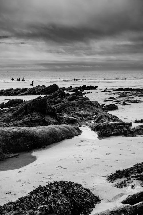 Black and White Photo of a Sandy Beach with Rocks