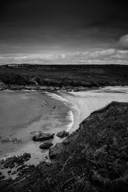 Scenic beach view in monochrome capturing rugged coastline and ocean waves.