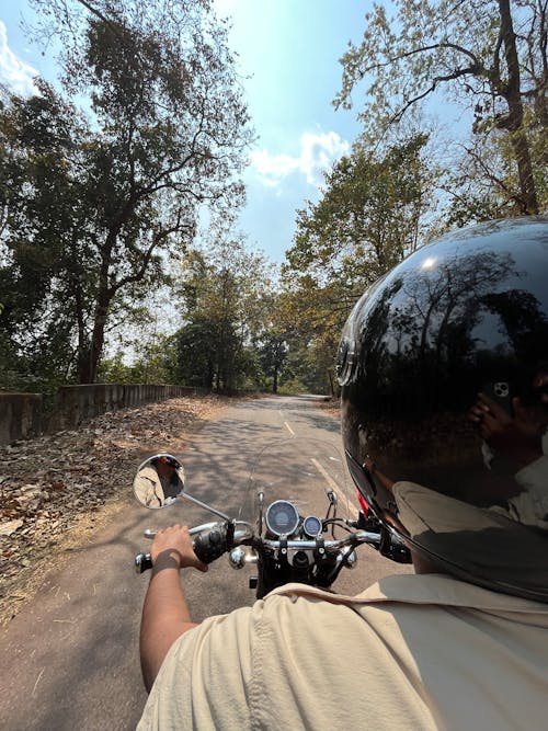 Photo of a Man Driving a Motorbike on a Country Road
