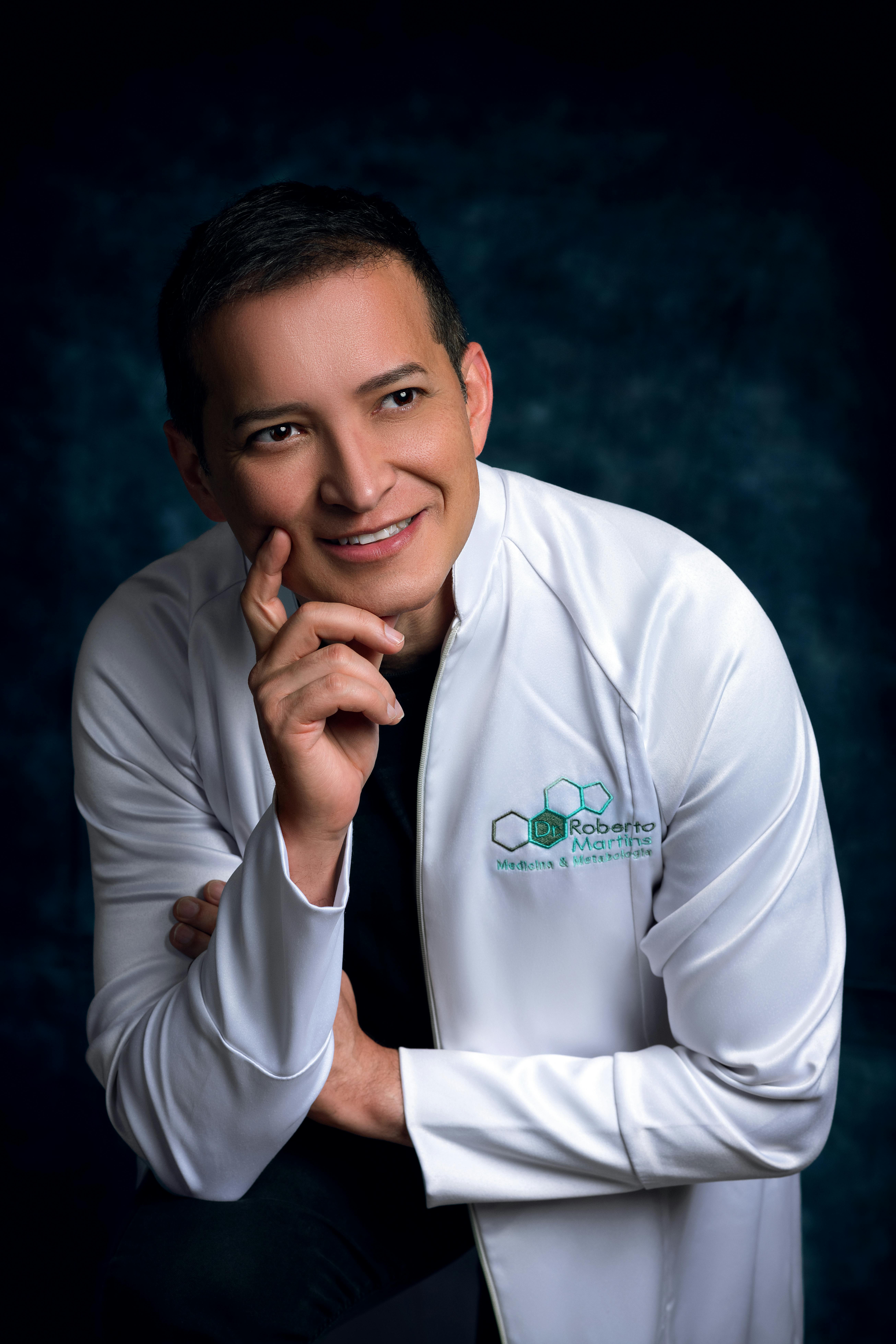 Confident doctor in a white coat smiling in a studio setting.
