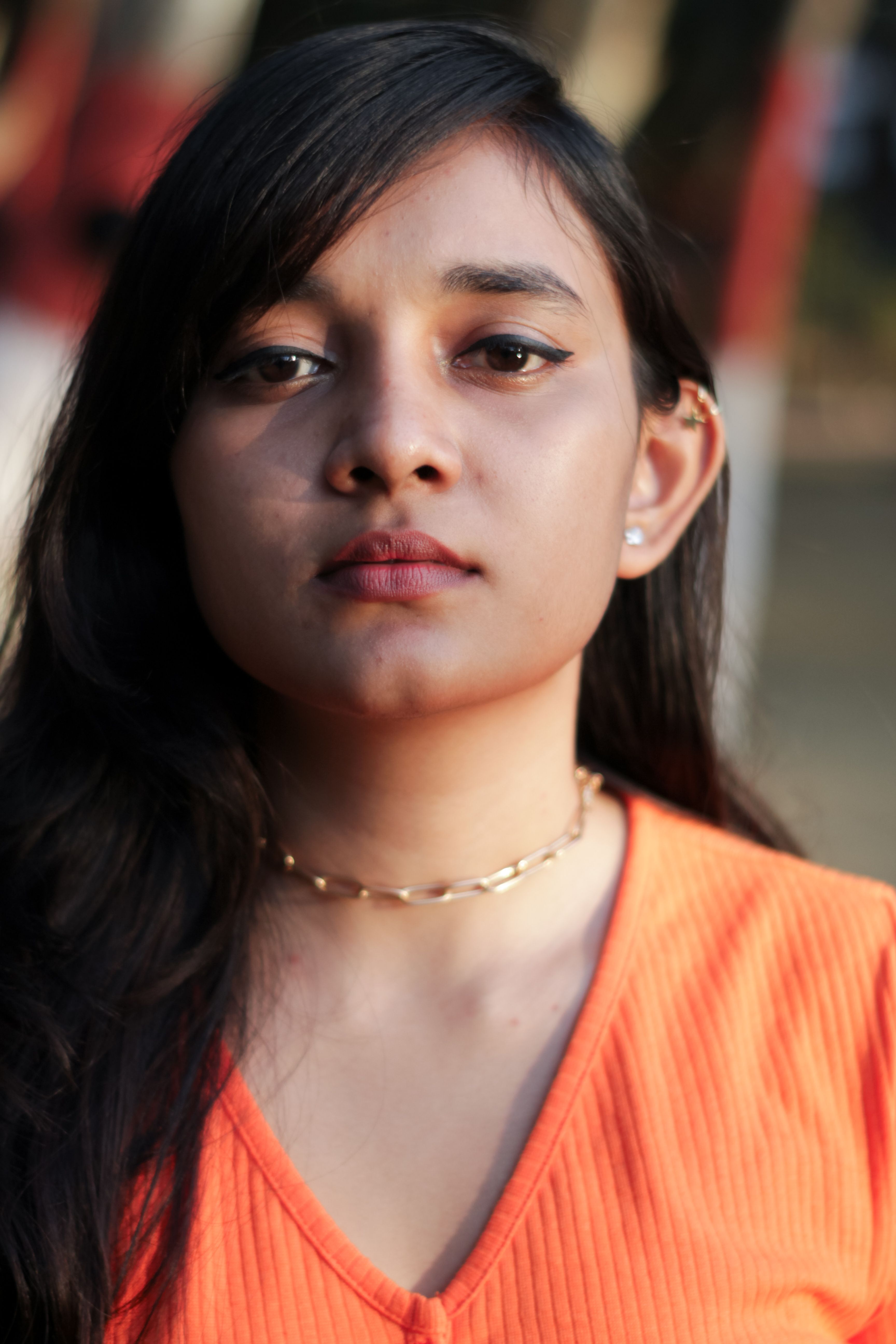 Close-up portrait of a South Asian woman with serious expression outdoors in Patna, India.