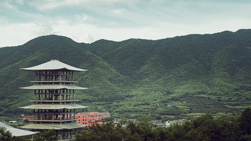 Free A serene view of a traditional pagoda set against green mountains, evoking tranquility. Stock Photo