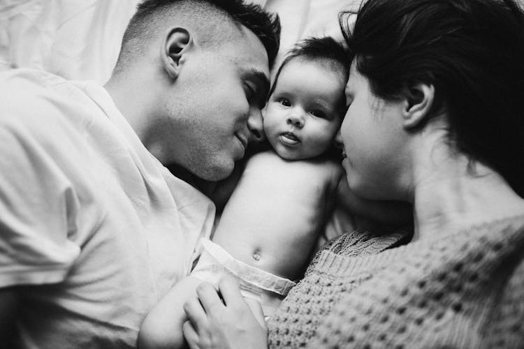 Couple Sleeping With Baby Between Them