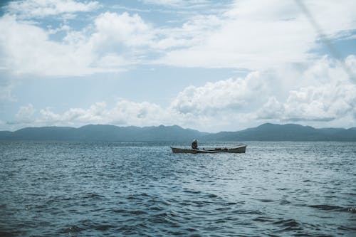 A Boat on the Sea and the View of Mountains in Distance 