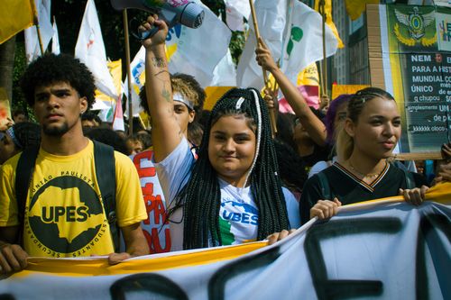 Free A vibrant youth protest with banners and flags, capturing activism in the urban environment. Stock Photo