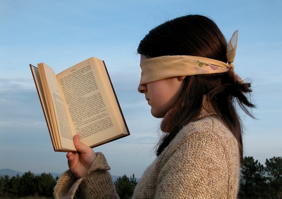 Woman Holding a Book While Her Head is Blindfolded