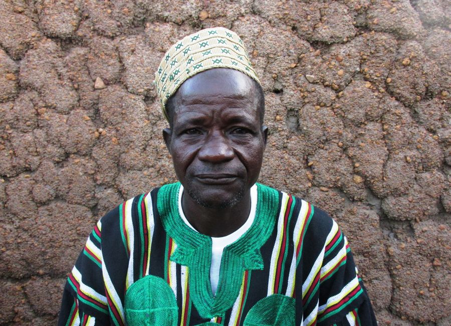 Elderly man in traditional clothing sitting in Togo village.