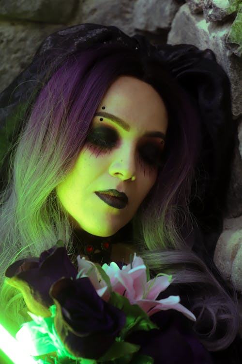 Woman Wearing a Wig and Halloween Makeup, Holding Flowers