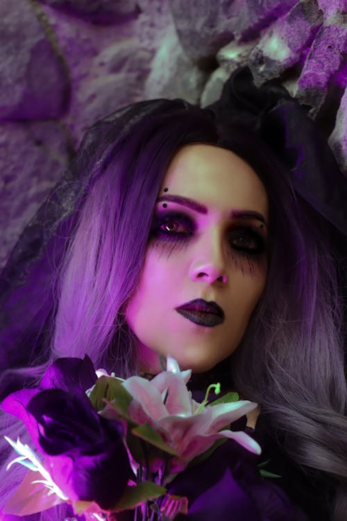 Woman Wearing a Wig and Halloween Makeup, Holding Flowers