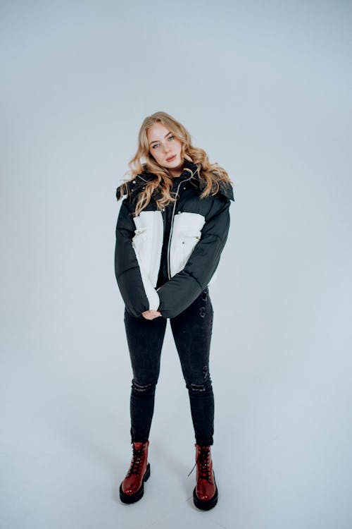 Young Woman Wearing a Jacket and Boots Posing in a Studio 