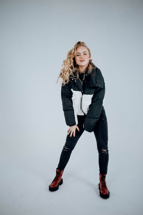 Young Woman Wearing a Jacket and Boots Posing in a Studio 