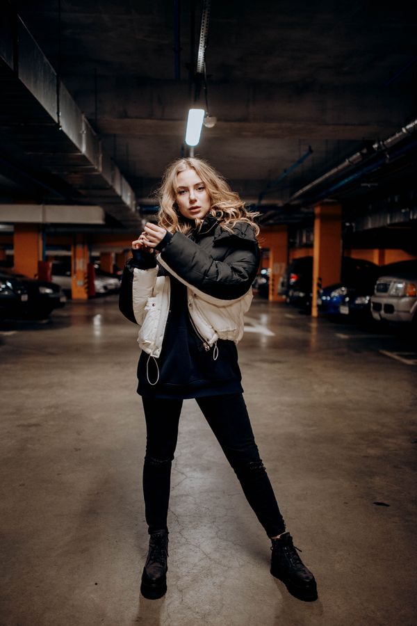 woman in black puffer vest and jeans with flat brown knee-high boots
