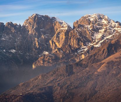 Breathtaking view of the Italian Dolomites with snow-capped peaks during sunset, showcasing nature's magnificence.