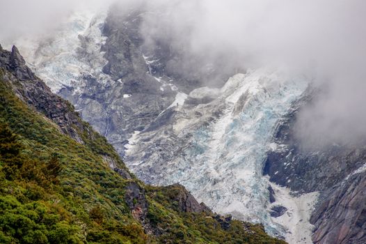 Breathtaking view of a glacier in Aoraki / Mount Cook National Park, New Zealand, draped in clouds.