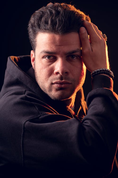 Studio Portrait of a Man Wearing a Black Hoodie 