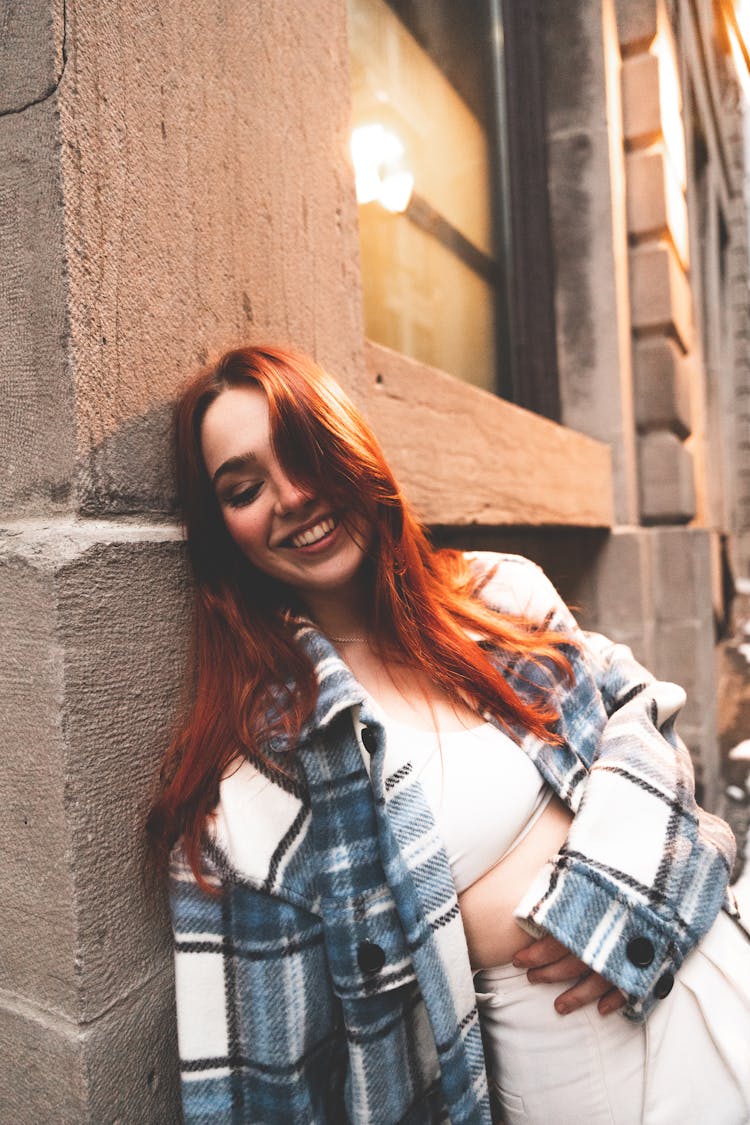 Redhead Woman Leaning On Wall