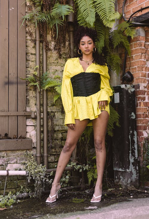 Young Woman Wearing a Yellow Shirt and a Corset Posing Outdoors 