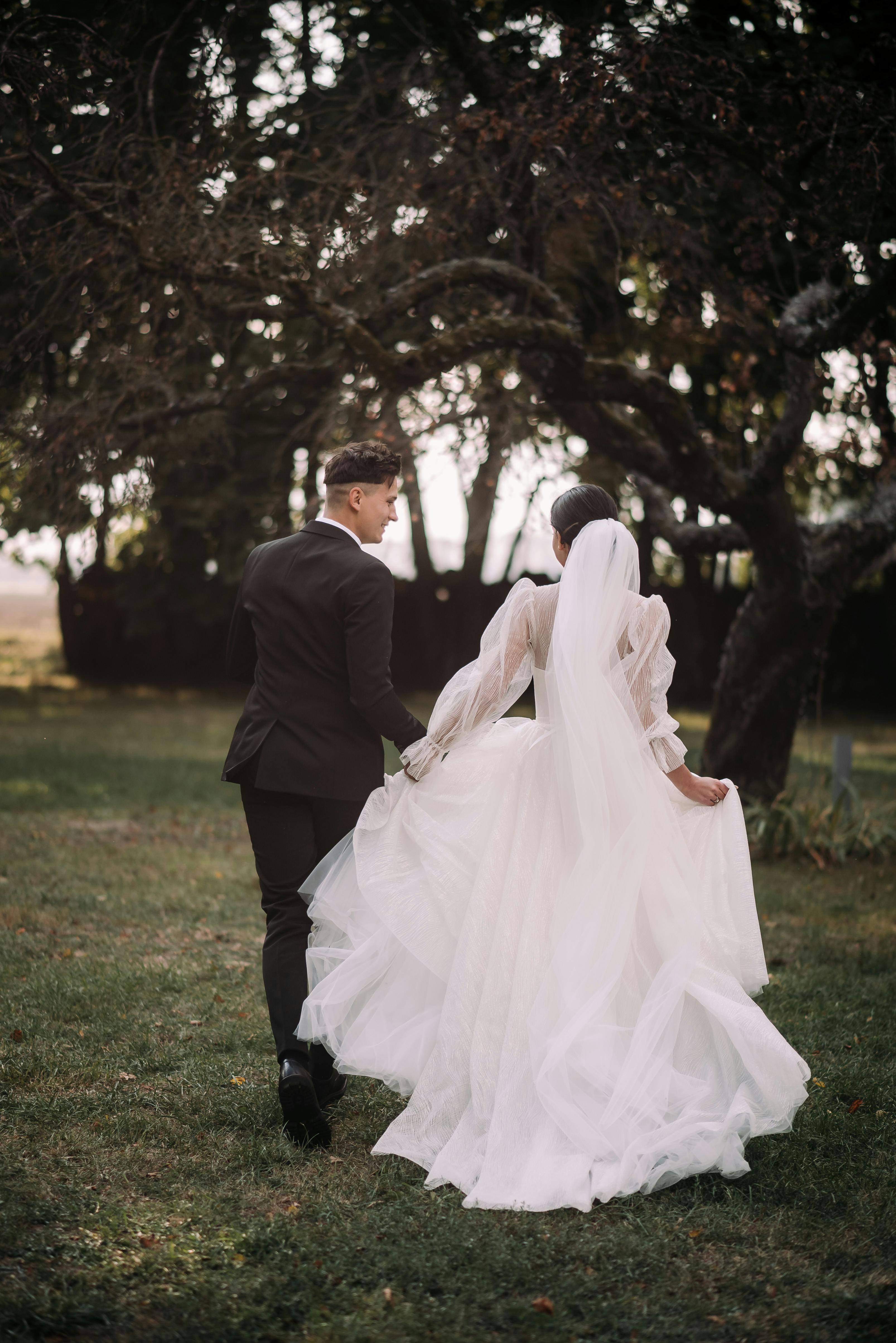 Bride and groom walking hand in hand through a serene garden, capturing a special moment.