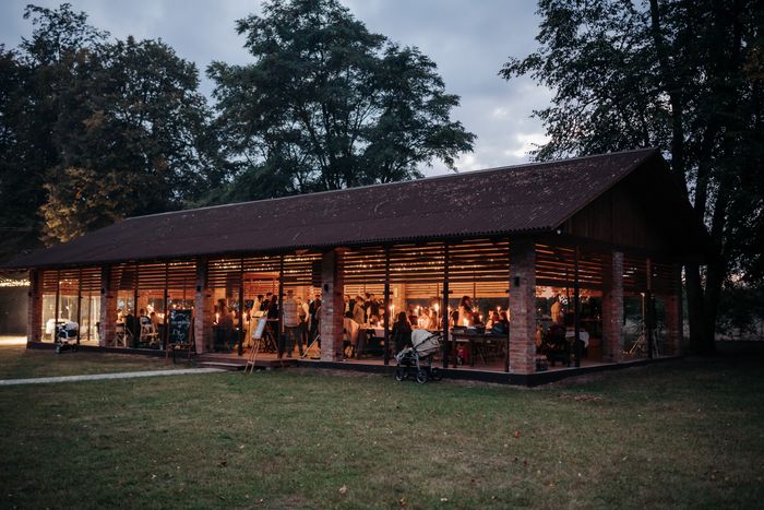 Glass pavilion venue glowing at dusk