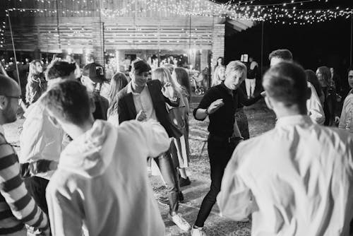 Black and White Photo of People Dancing at Night 