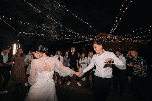 Newlyweds Dancing in a Crowd at Night