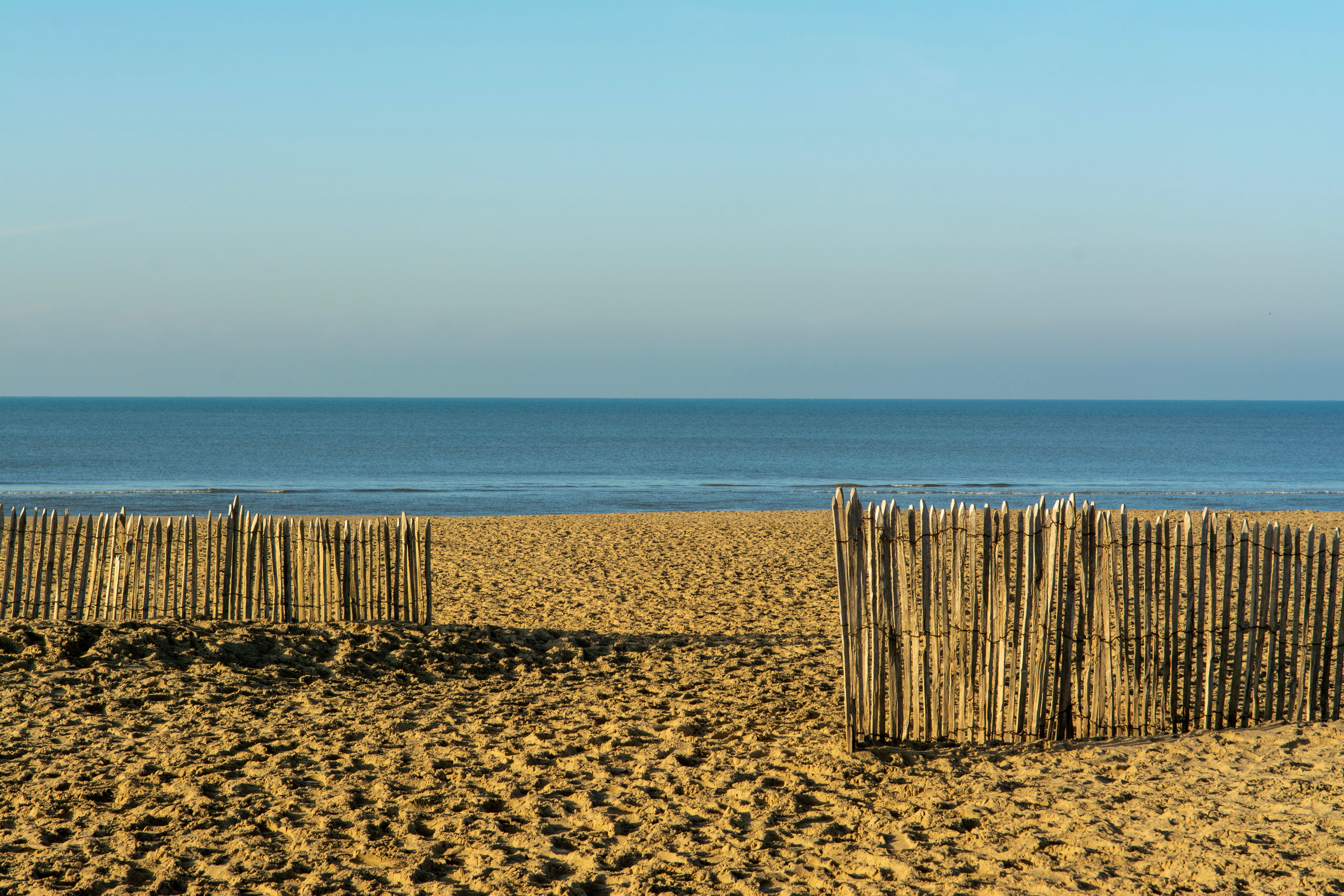 A Wooden Fence on the Beach and a Seascape under a Blue Sky · Free ...
