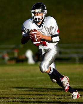 A focused young athlete playing quarterback during a daytime football game.