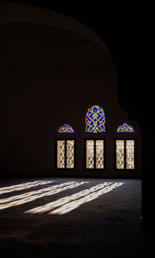 Free Sunlit stained glass windows cast colorful patterns inside an Istanbul mosque. Stock Photo