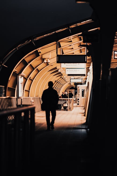 Silhouette of a Person Walking on a Railway Station 