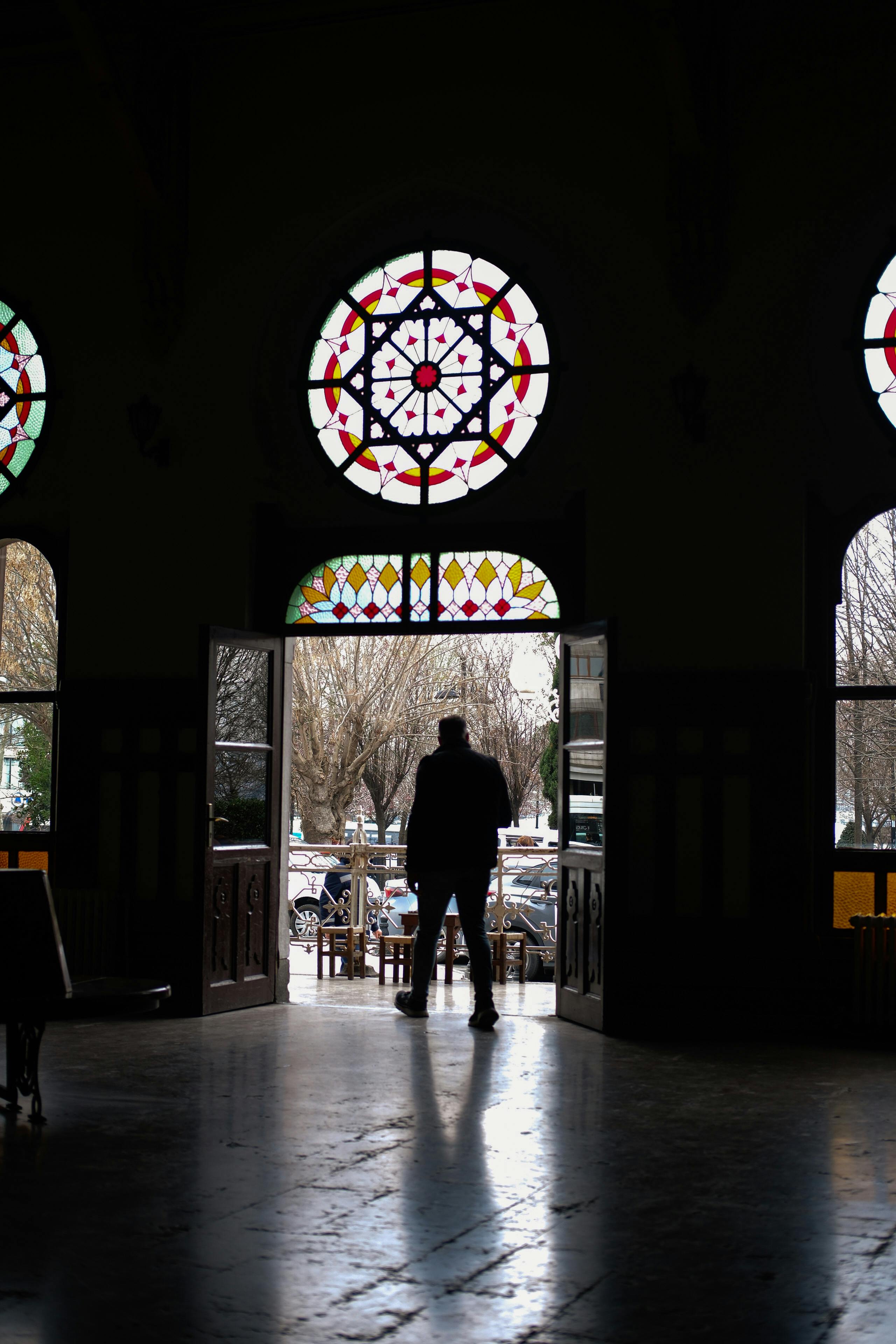 a man is standing in front of stained glass windows