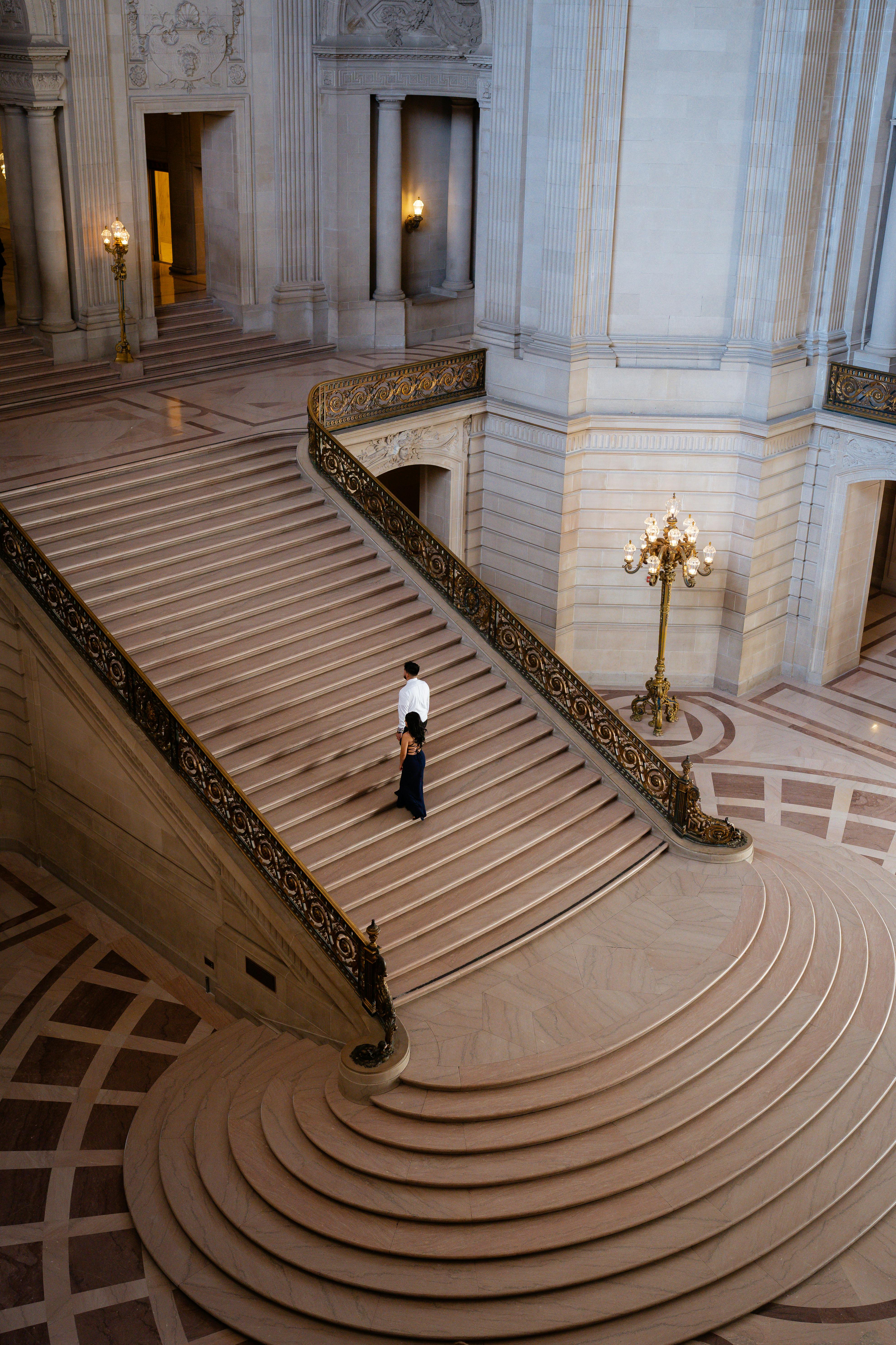 A man descending an ornate staircase in a luxurious interior, exuding elegance and grandeur.