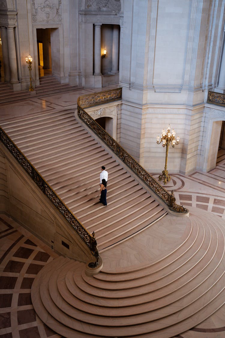 Elegant Man And Woman Walking Up The Stairs In A Palace 