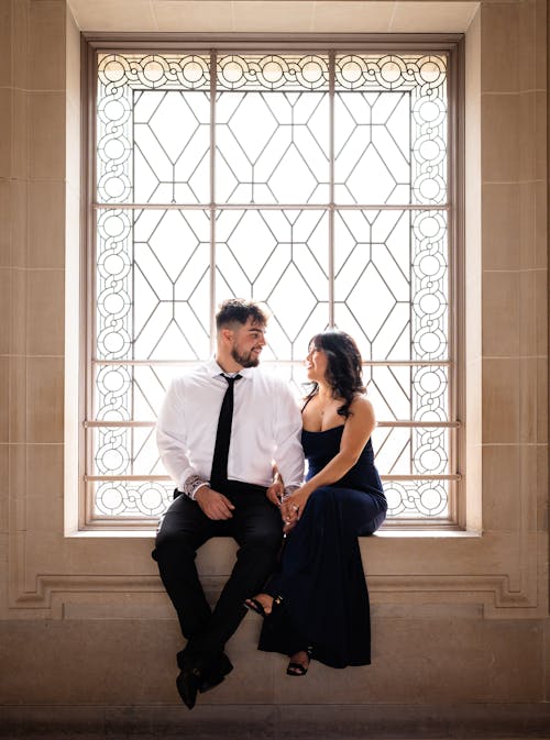 Elegant Couple Sitting on a Windowsill in a Palace 